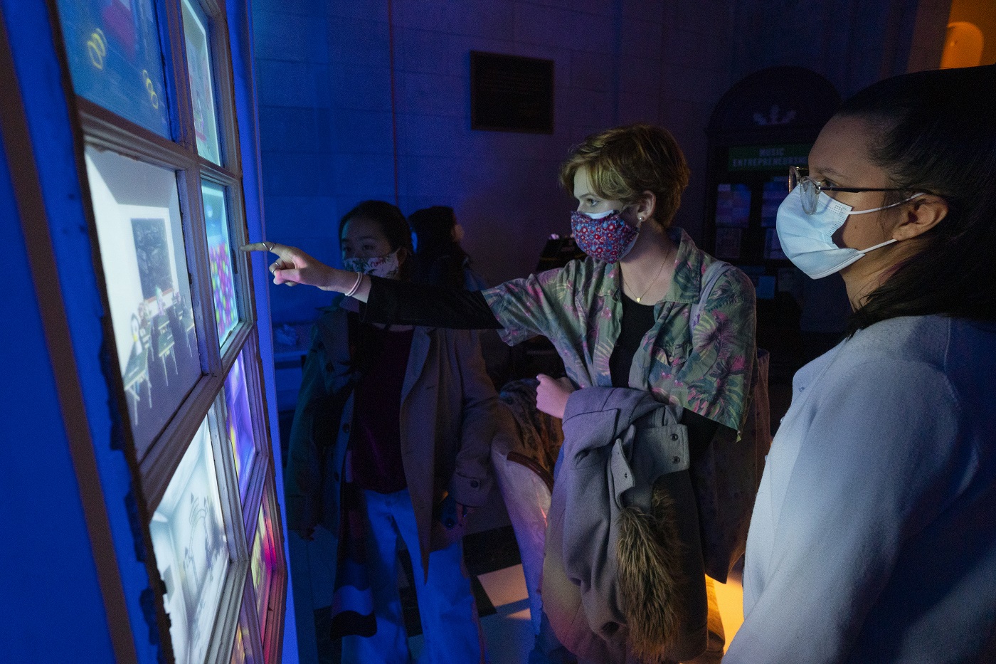 Visitors to an Exploded Ensemble event looking at screens and pointing
