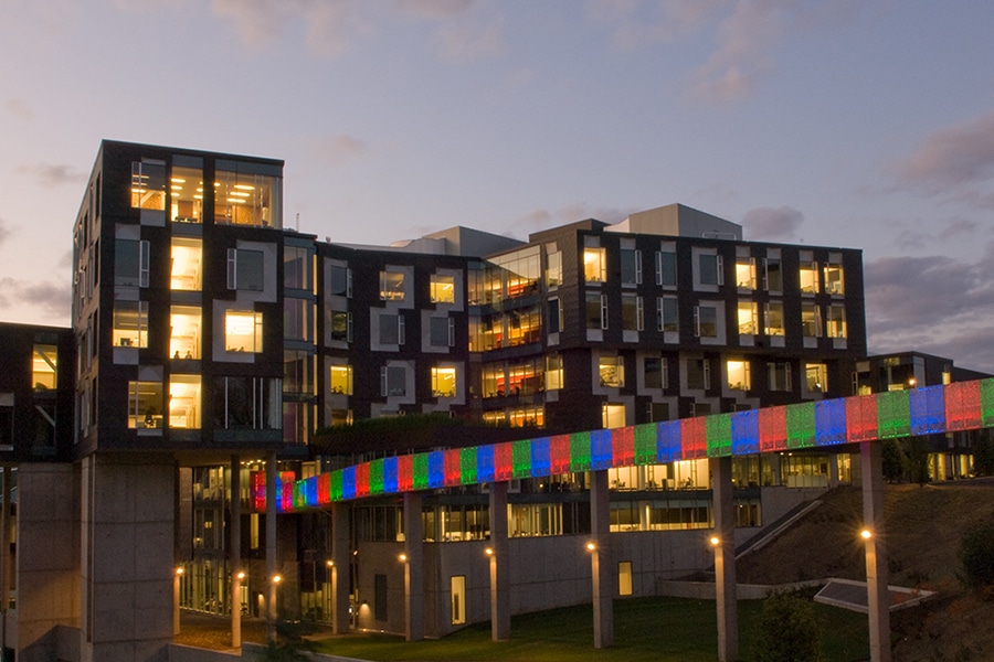 Gates building at dusk with Pausch bridge in foreground. Bridge is lit in green, blue, red pattern