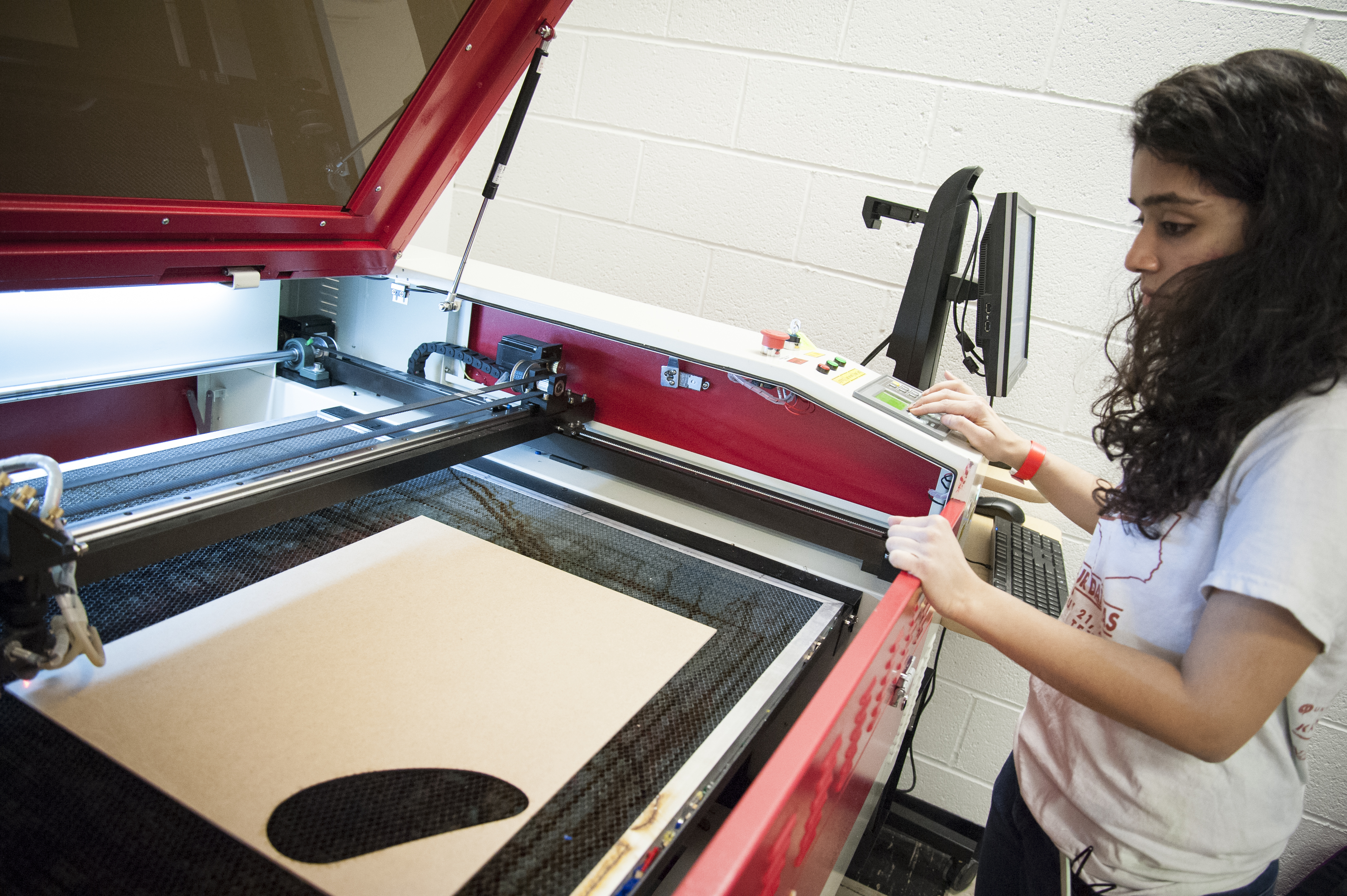 student working at laser cutter