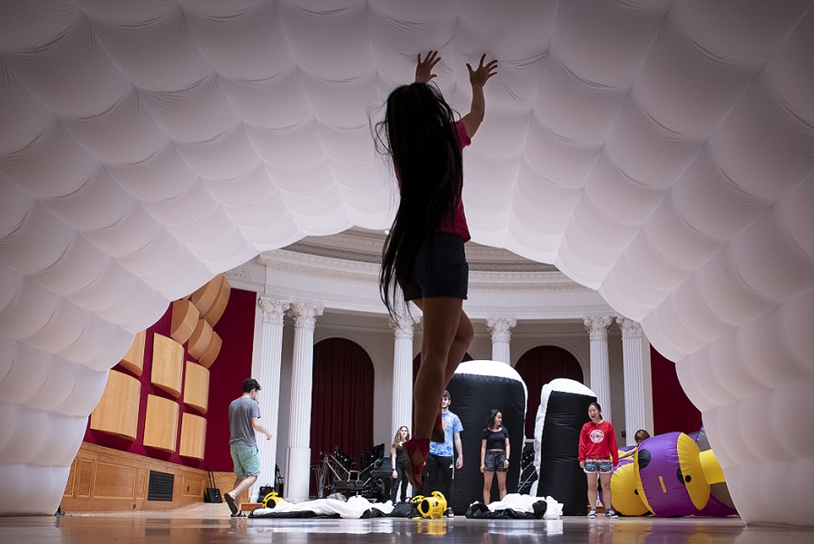 Student leaping and touching an inflatable sculpture