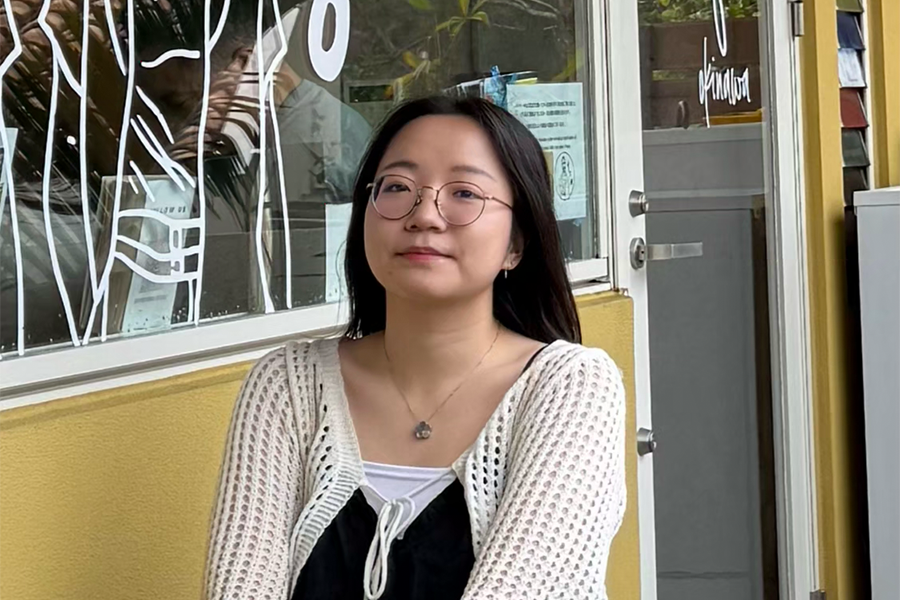 a portrait of Daphne, a young student with dark hair and glasses