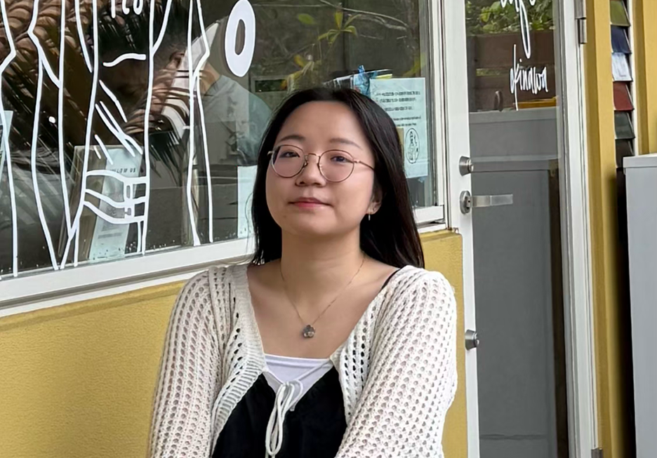 a portrait of Daphne, a young student with dark hair and glasses