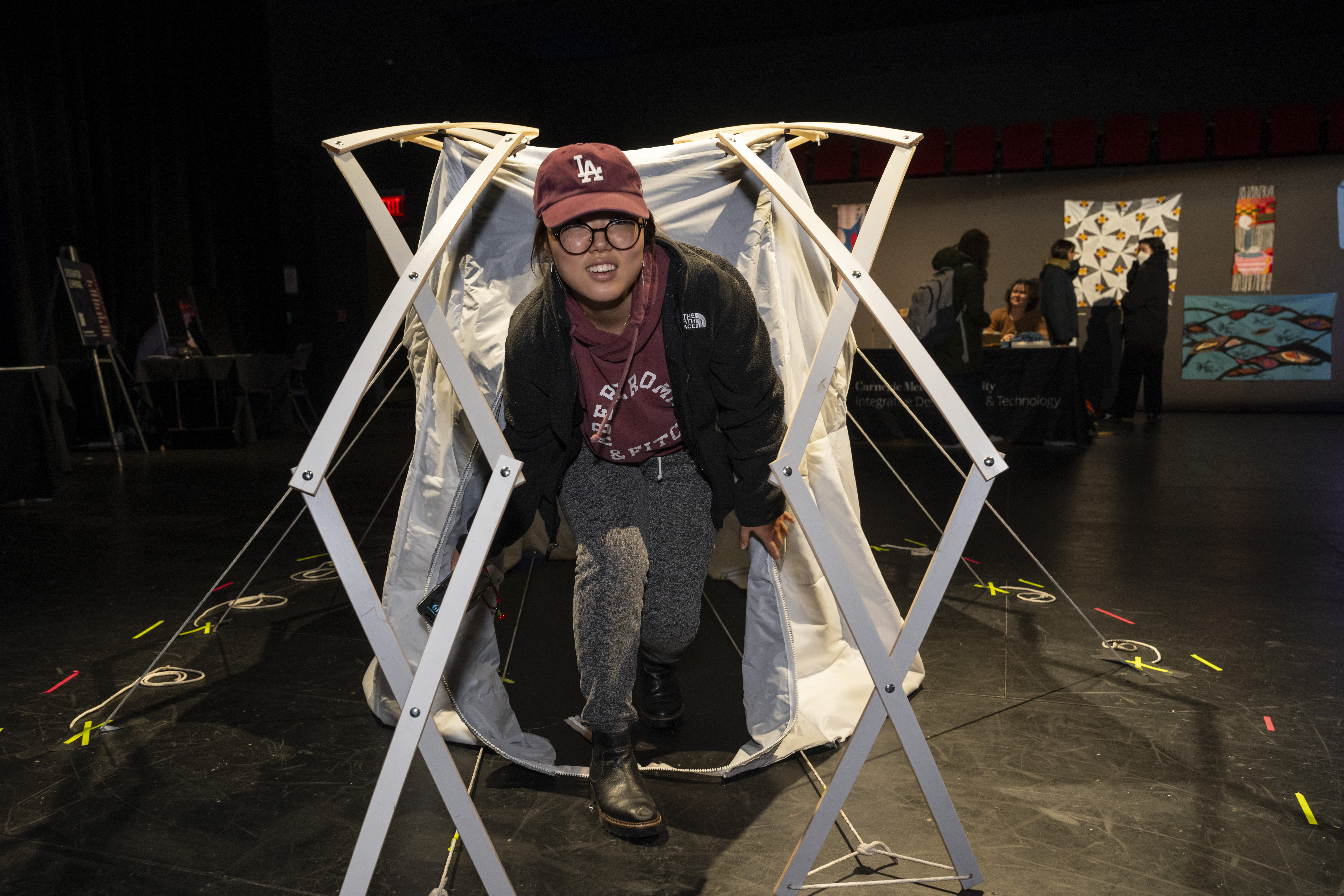 student emerges from a makeshift tent