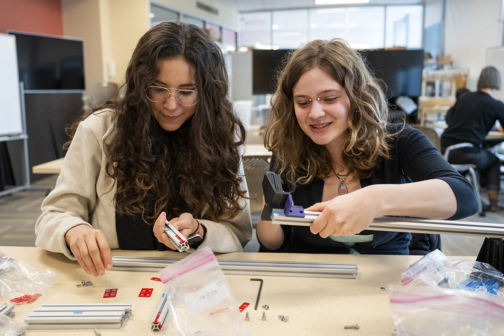 two students work with tools in an IDeATe class