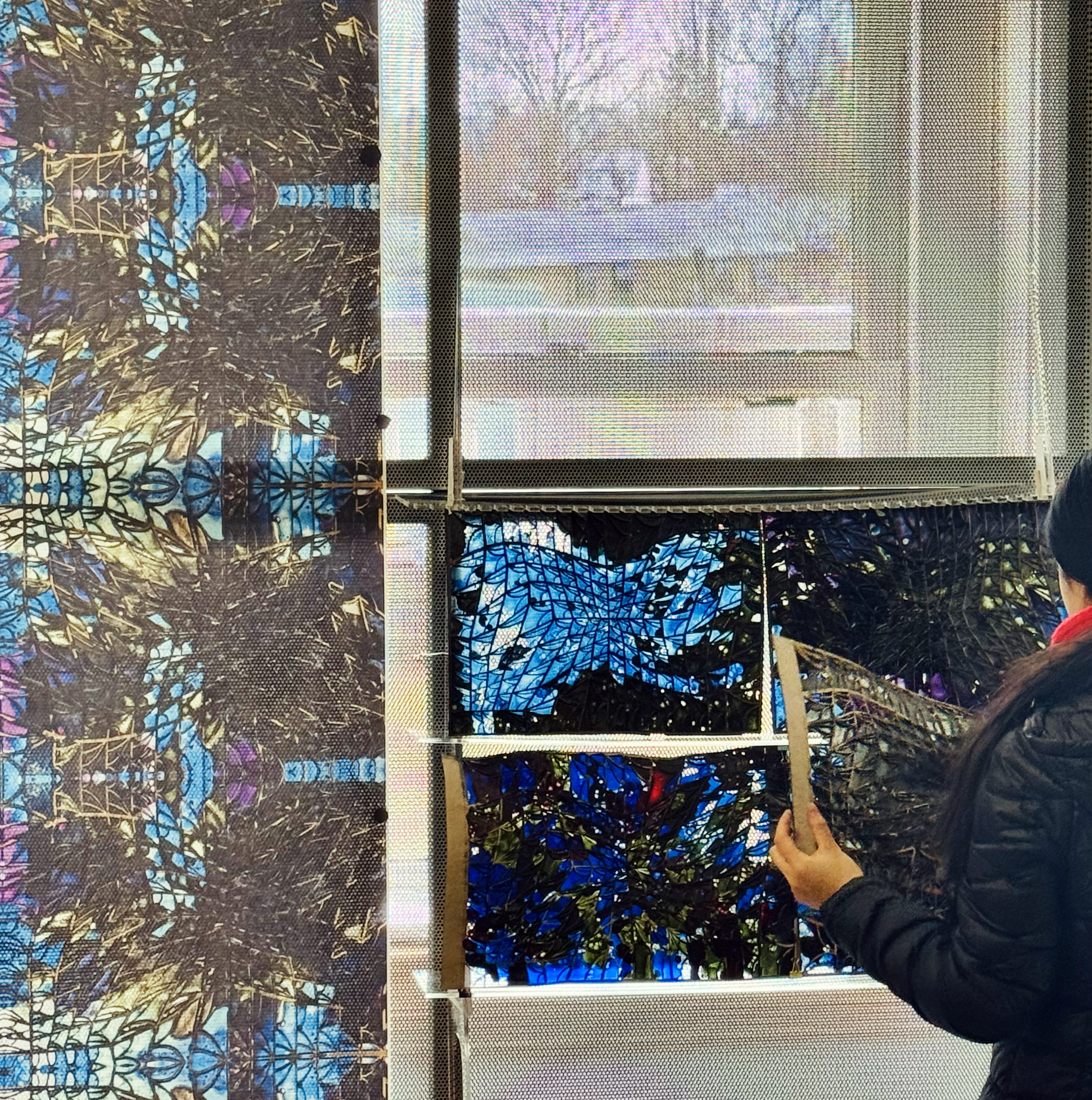 a visitor examines a wall of stained glass in the exhibit