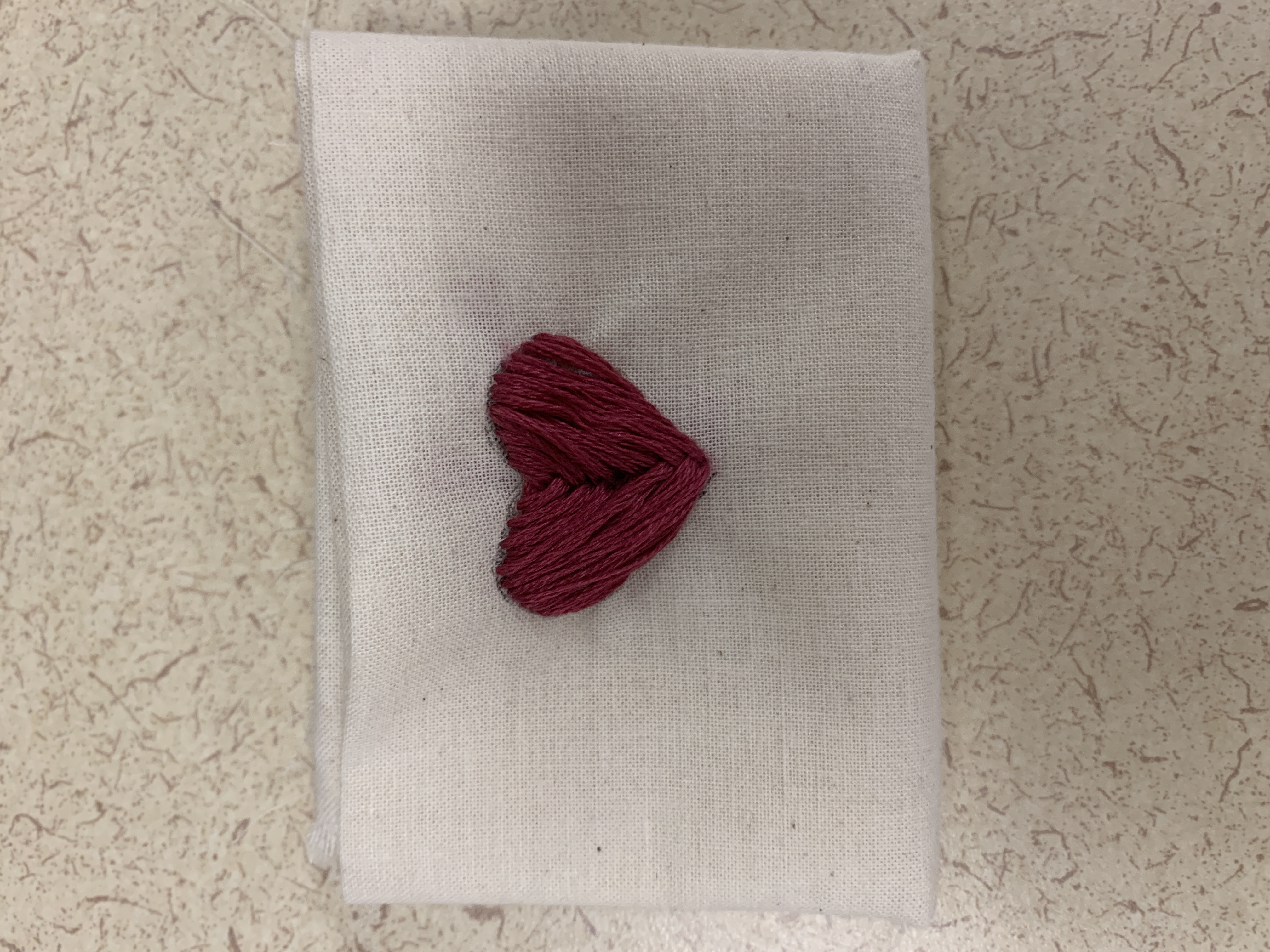 a red heart stitched onto white fabric.jpg