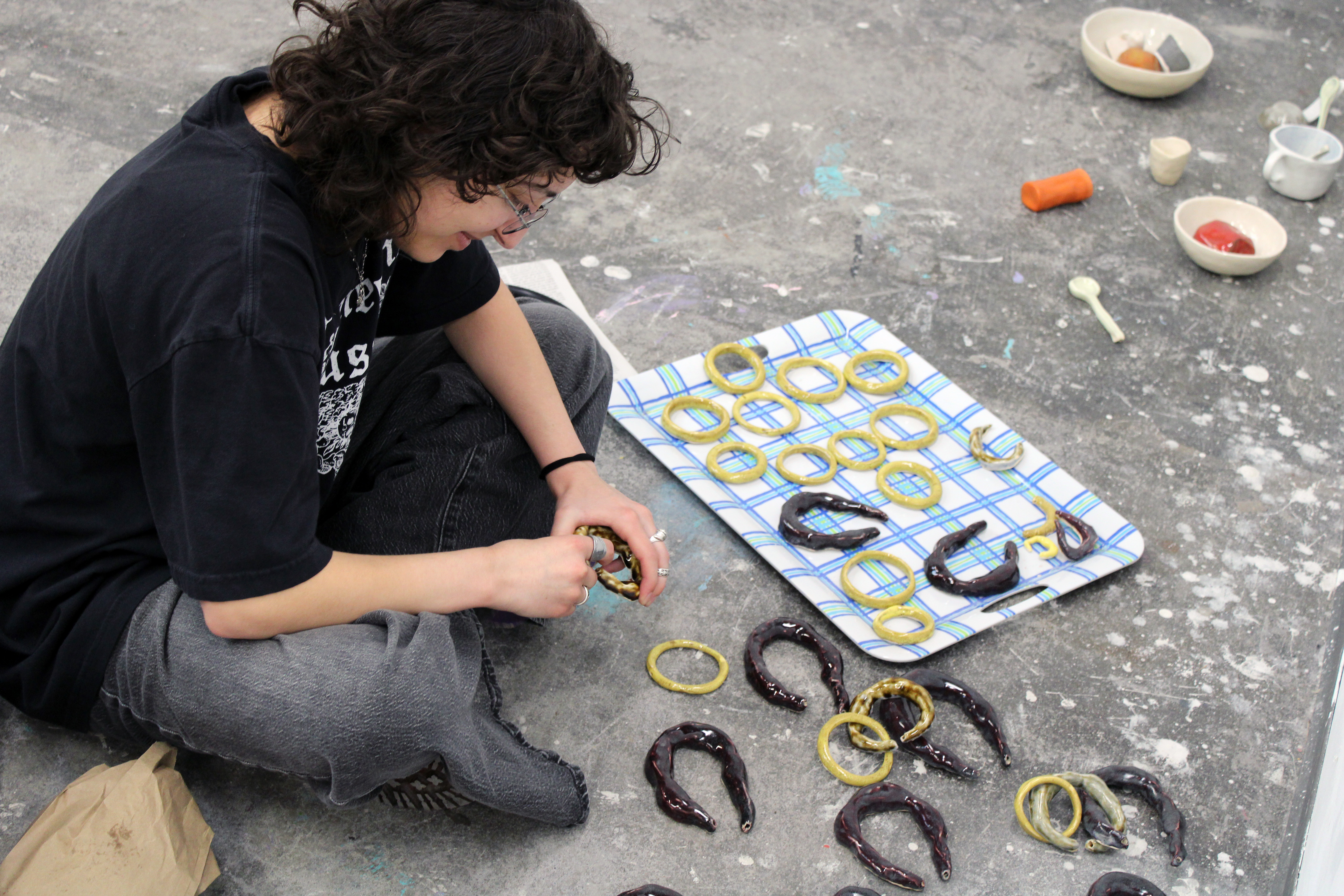 a student lays out black and yellow worm pieces on a blue tray