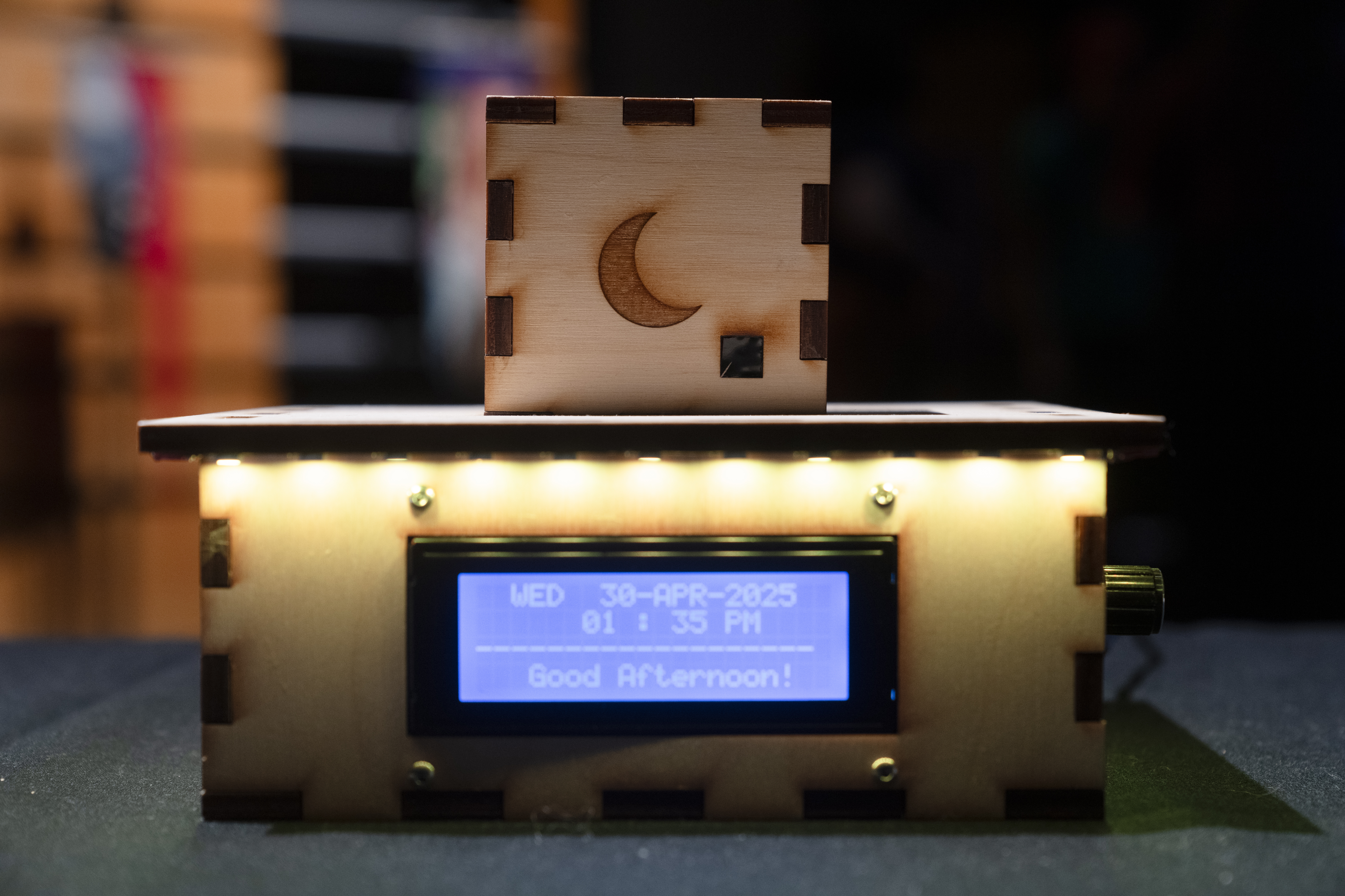 a wood protype with a screen that reads lists the date and time and reads "good afternoon"