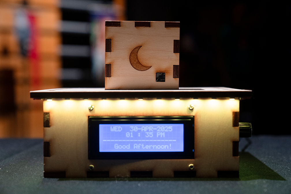 a wood protype with a screen that reads lists the date and time and reads "good afternoon"