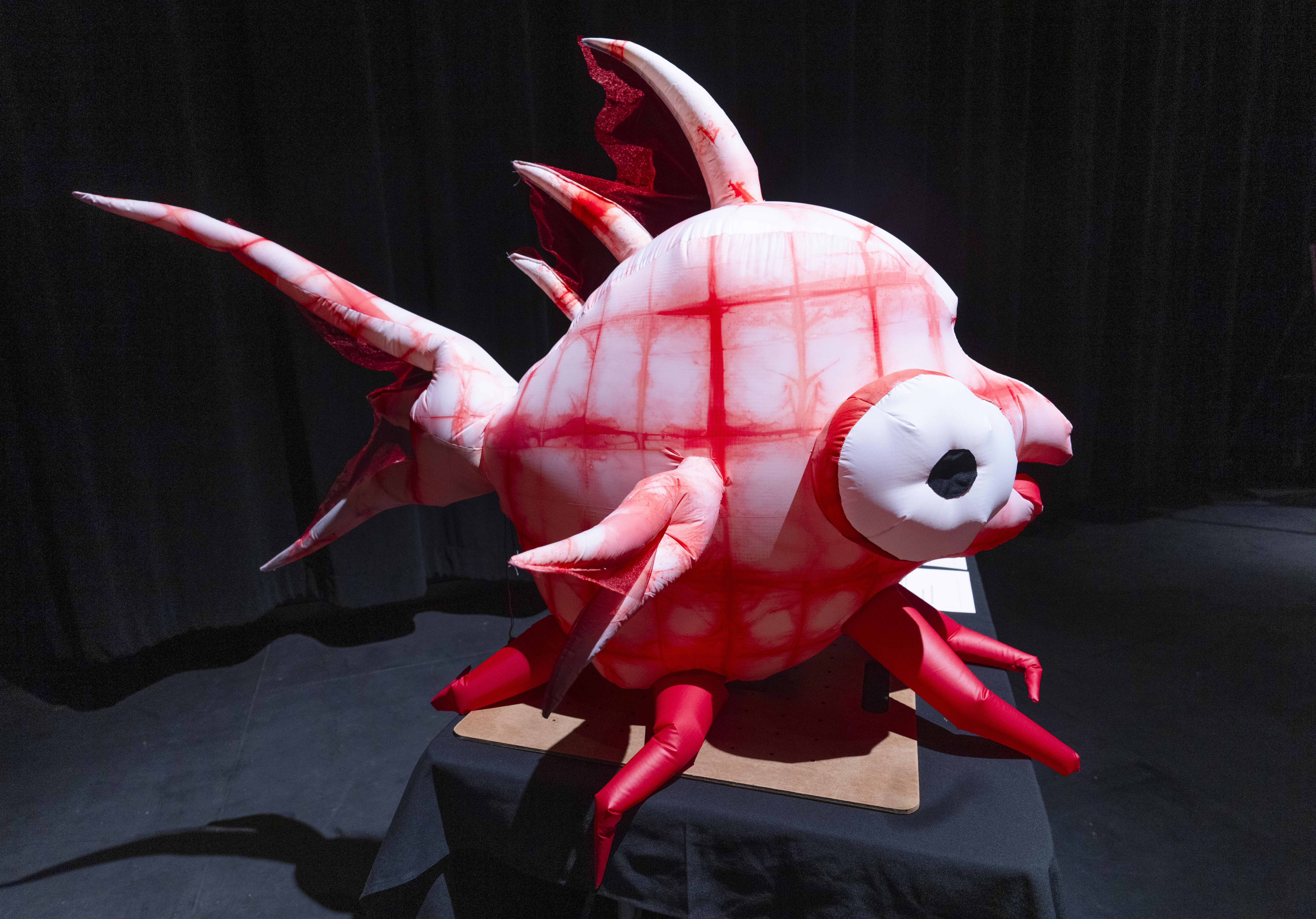 a large pink inflatable fish with bulging eyes and spikes