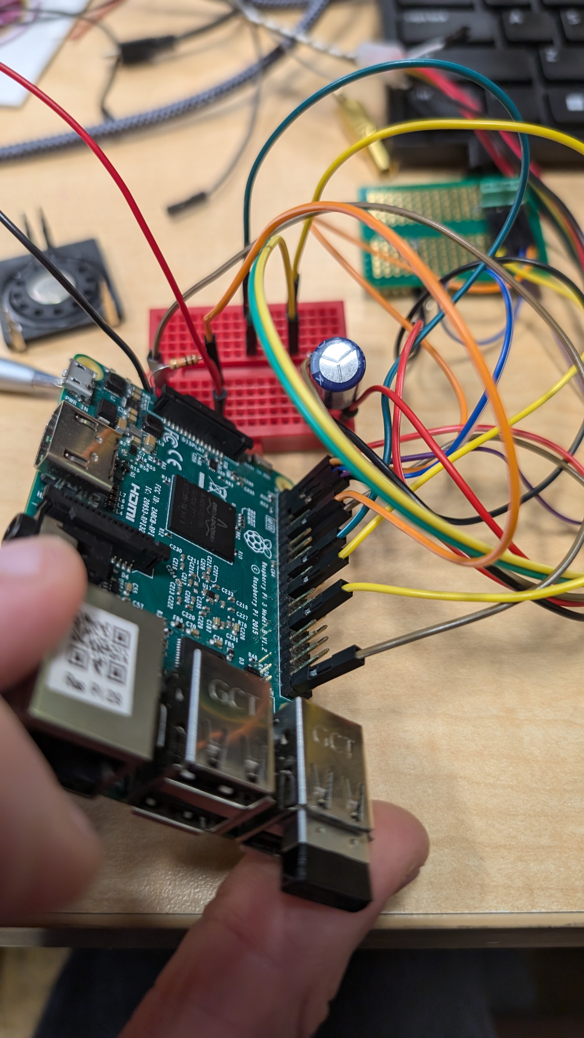 a circuit board connected to multiple colored wires make up some of the technology inside a Plush Neuron